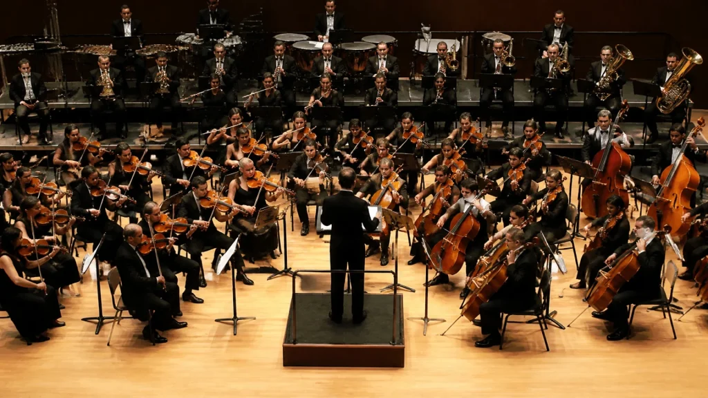 Quelle famille d’instruments est placée devant le chef d’orchestre ?